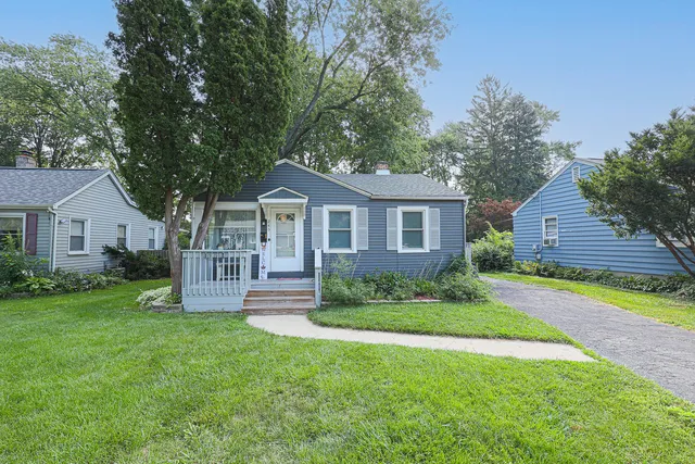 a front view of a house with a yard and green space