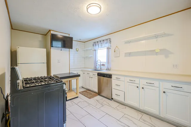 a kitchen with stainless steel appliances granite countertop a stove a sink and a refrigerator