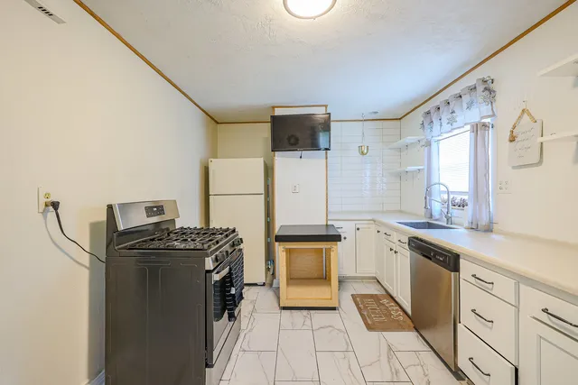 a kitchen with a stove top oven and refrigerator