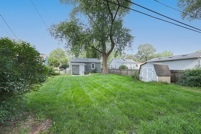 a view of a house with a yard and tree s