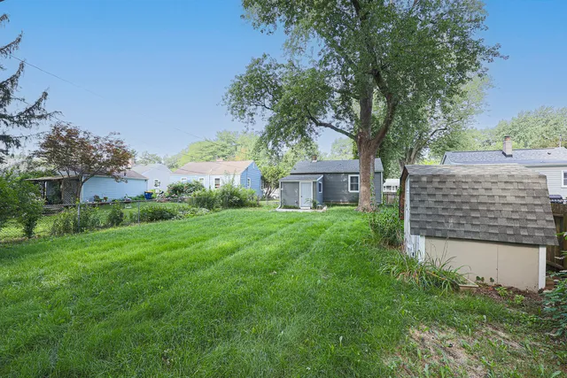 a view of a house with a yard and a large tree