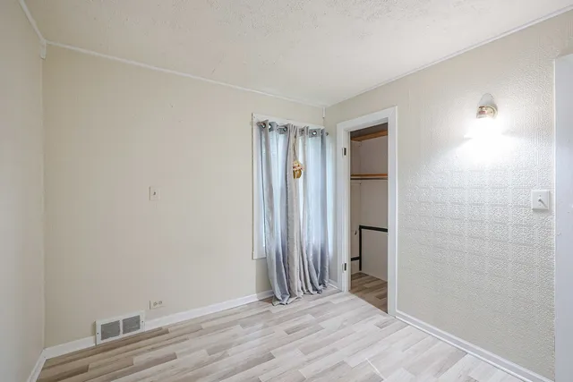 a view of an empty room with wooden floor