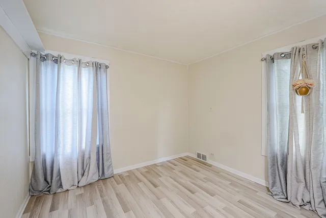 a view of a room with wooden floor and a shower