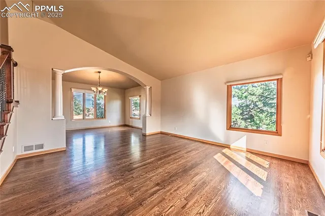 a kitchen with a sink appliances wooden floor and a window