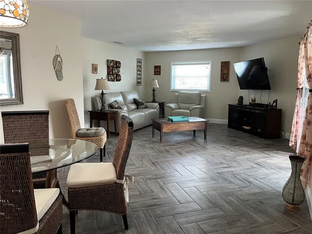 a living room with furniture a window and a flat screen tv