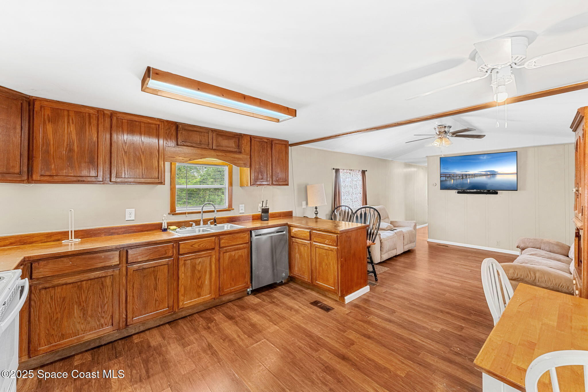 517 Bowman Boulevard Cocoa, FL 32927 - Photo 15 of 38 a large kitchen with stainless steel appliances granite countertop a sink dishwasher a dining table and chair with wooden floor