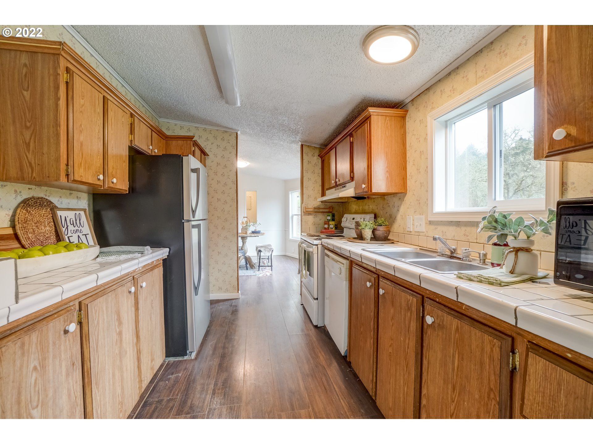 6967 Southwest Mill Road Gaston, OR 97119 - Photo 7 of 28 a kitchen with stainless steel appliances granite countertop a refrigerator a sink dishwasher a stove with wooden cabinets and floor
