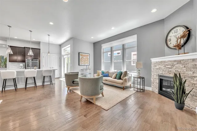 a living room with furniture a fireplace and a large window