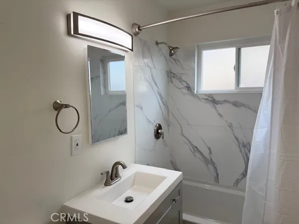 a bathroom with a sink and mirror with toilet