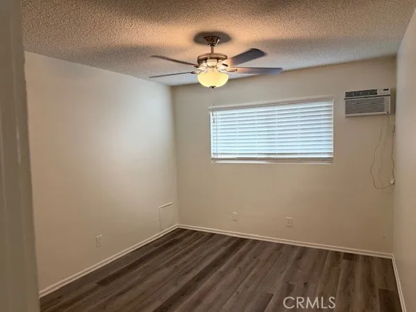 a view of wooden floor and a chandelier fan in a room