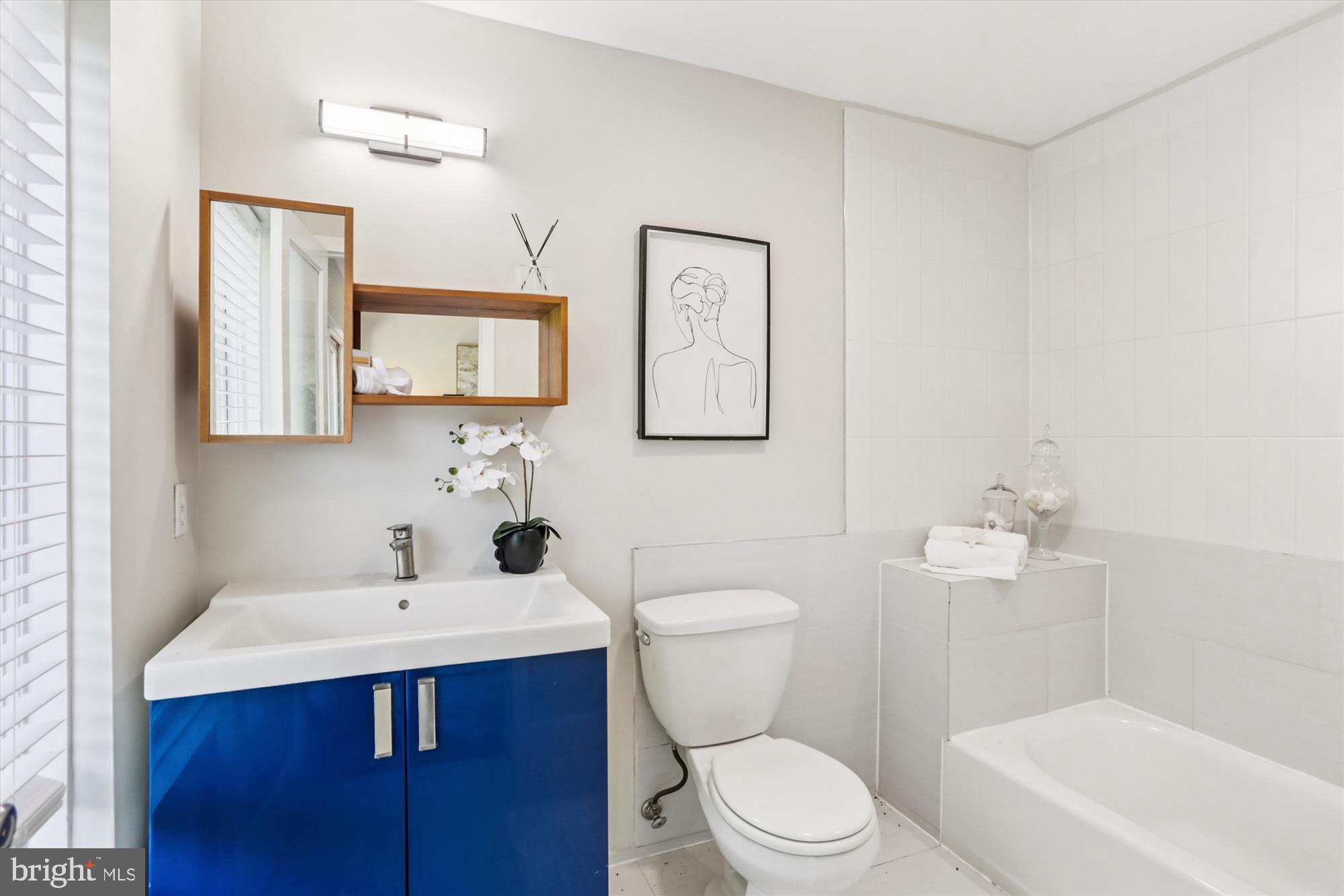 3222 13th Street Northwest, Unit 2 Washington, DC 20010 - Photo 39 of 52 a bathroom with a toilet a sink a mirror and vanity