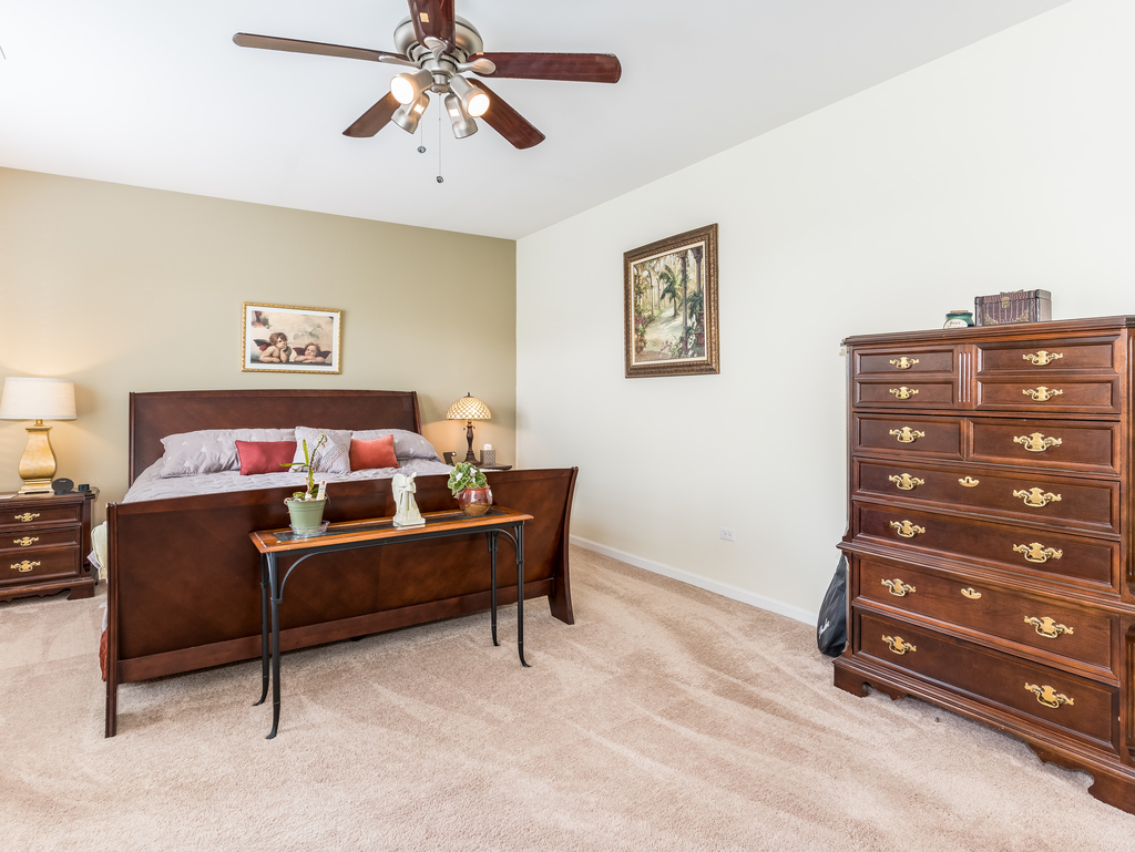 1927 Chase Lane, Unit 1927 Aurora, IL 60502 - Photo 20 of 24 a bedroom with a bed and a chandelier