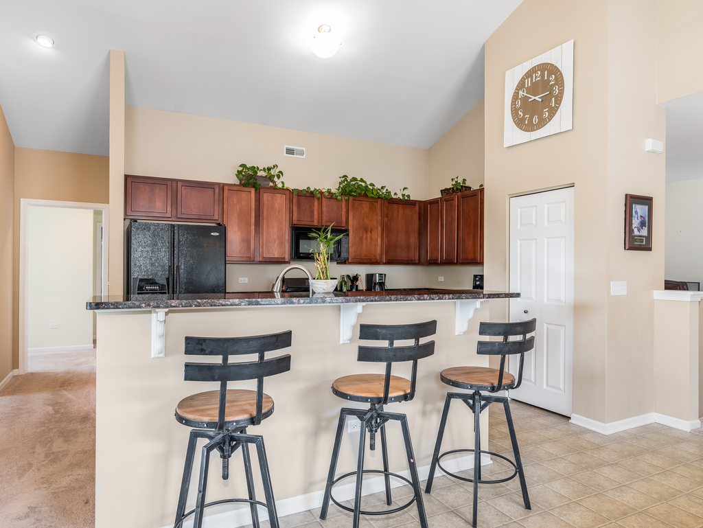 1927 Chase Lane, Unit 1927 Aurora, IL 60502 - Photo 5 of 24 a kitchen with stainless steel appliances a table and chairs in it