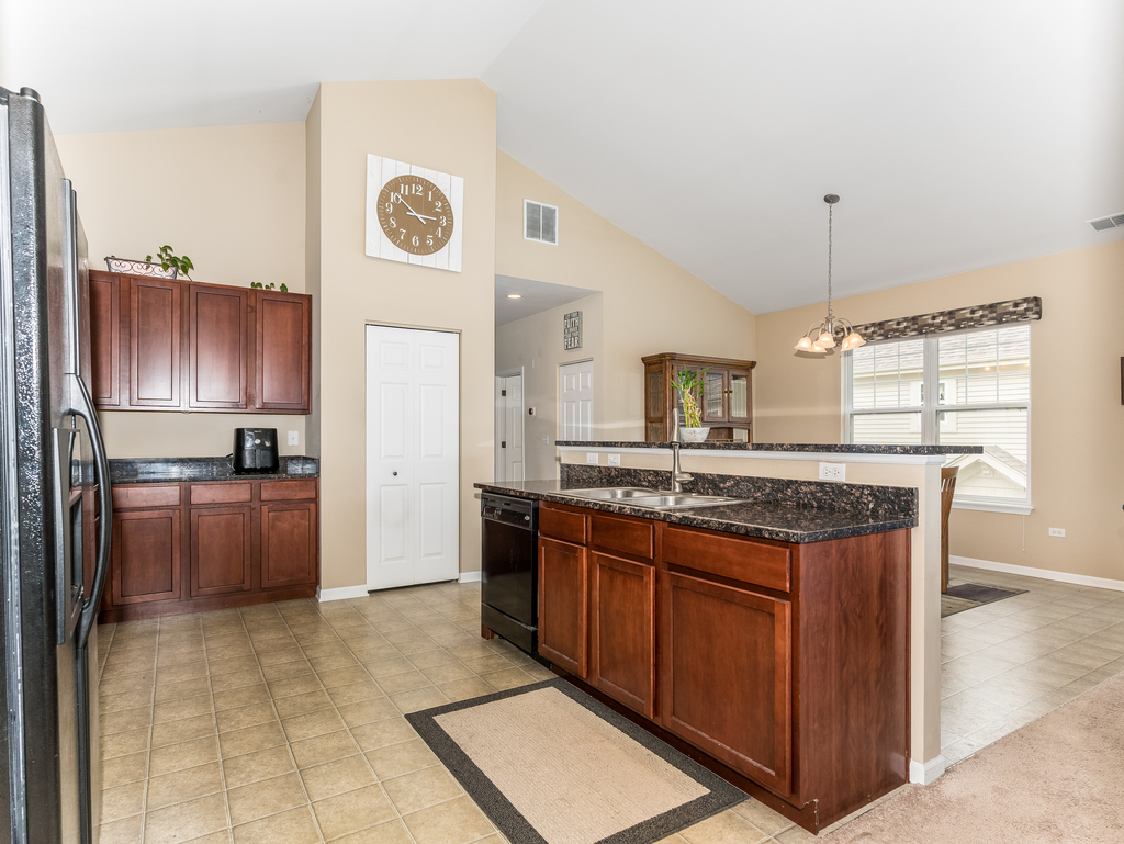1927 Chase Lane, Unit 1927 Aurora, IL 60502 - Photo 7 of 24 a kitchen with stainless steel appliances granite countertop a stove a sink dishwasher and a refrigerator with wooden floor
