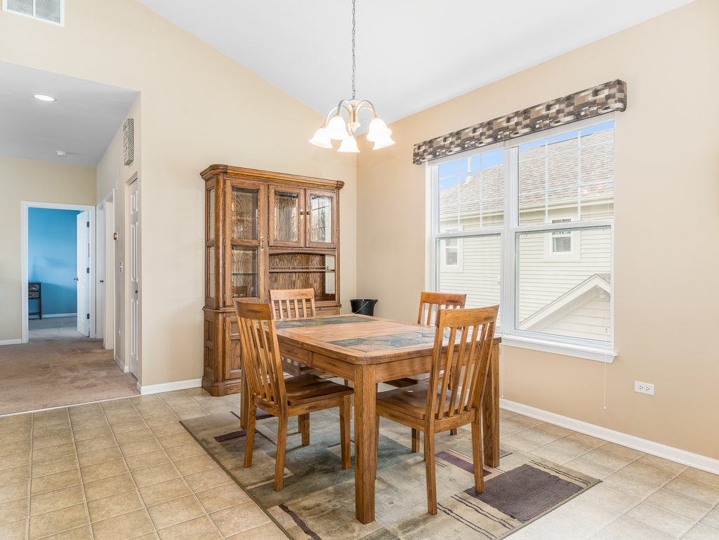 1927 Chase Lane, Unit 1927 Aurora, IL 60502 - Photo 8 of 24 a view of a dining room with furniture and a chandelier
