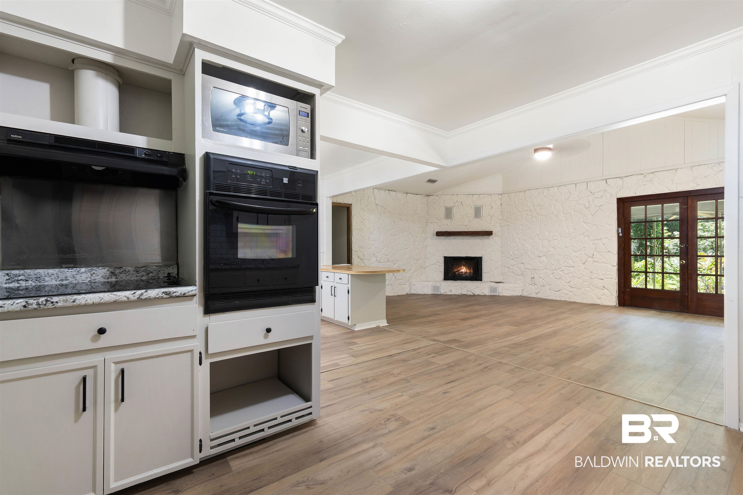 4667 Bit And Spur Road Mobile, AL 36608 - Photo 11 of 27 Kitchen featuring stainless steel microwave, black oven, and light wood-type flooring