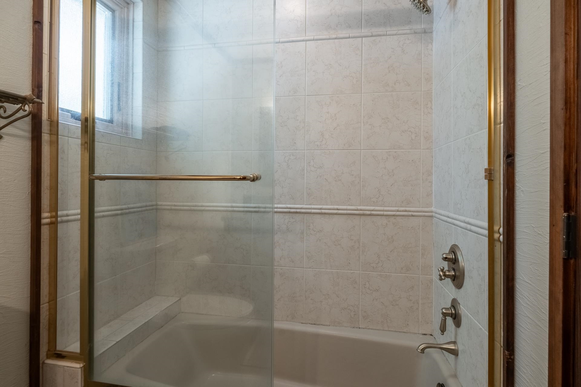 139 Ridgecrest Drive Mammoth Lakes, CA 93546 - Photo 45 of 65 Bathtub and shower combination featuring a glass enclosure with brass-finish framing