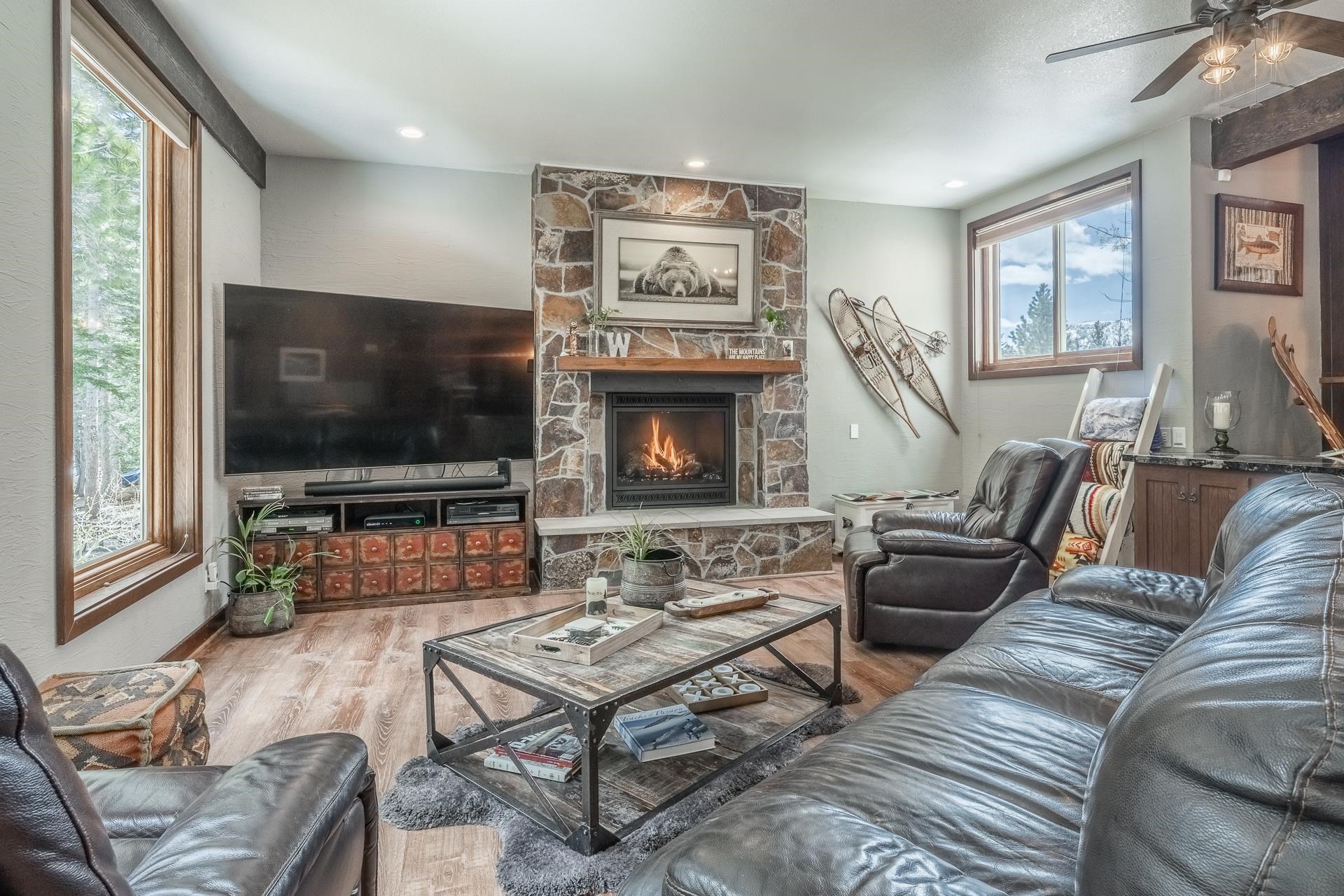 139 Ridgecrest Drive Mammoth Lakes, CA 93546 - Photo 8 of 65 Living area featuring a floor-to-ceiling stone fireplace with a wood mantle, wood-finish flooring, recessed lighting, and large windows with natural wood trim