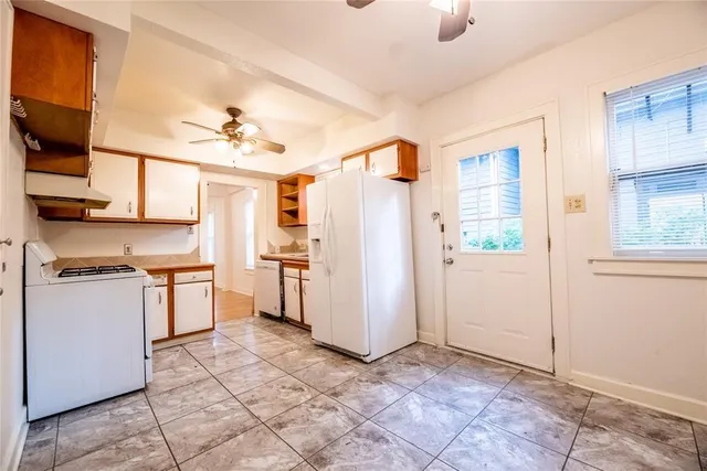 a kitchen with a stove a refrigerator and cabinets