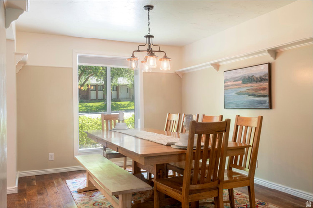 9676 Mt Jordan Road Sandy, UT 84092 - Photo 11 of 38 Bright dining space featuring wood-finish flooring, a contemporary chandelier, large picture window, and decorative wall corbels