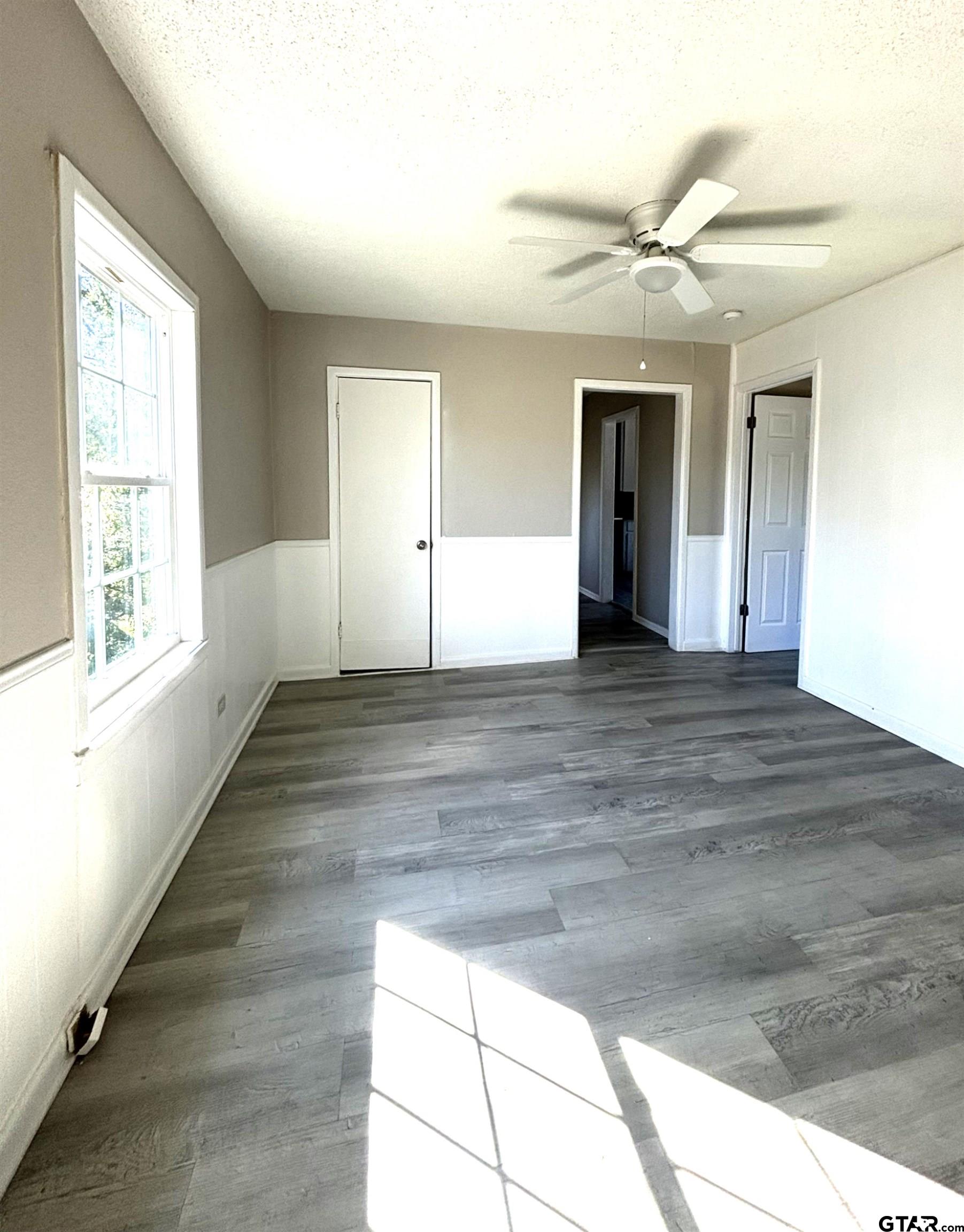 1511 Summit Avenue, Unit 3 Tyler, TX 75702 - Photo 7 of 8 a view of an empty room with wooden floor and a window