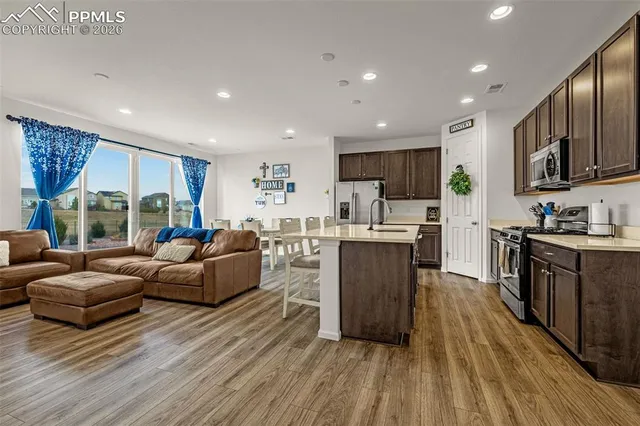 a living room with stainless steel appliances furniture and a large window
