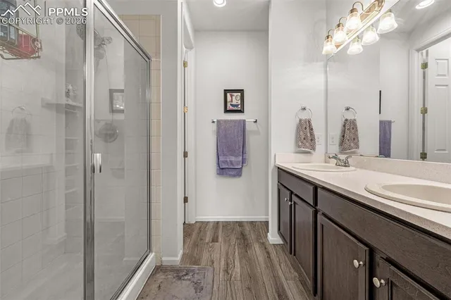 a bathroom with a double vanity sink mirror and shower
