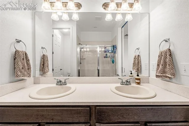 a bathroom with double vanity sinks and a mirror