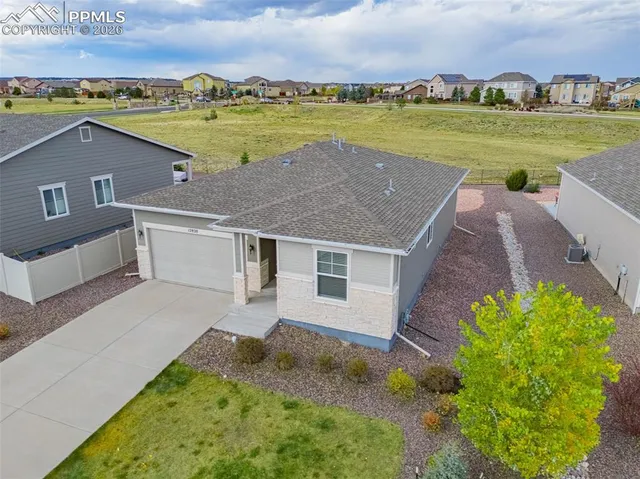 an aerial view of a house with a garden and lake view