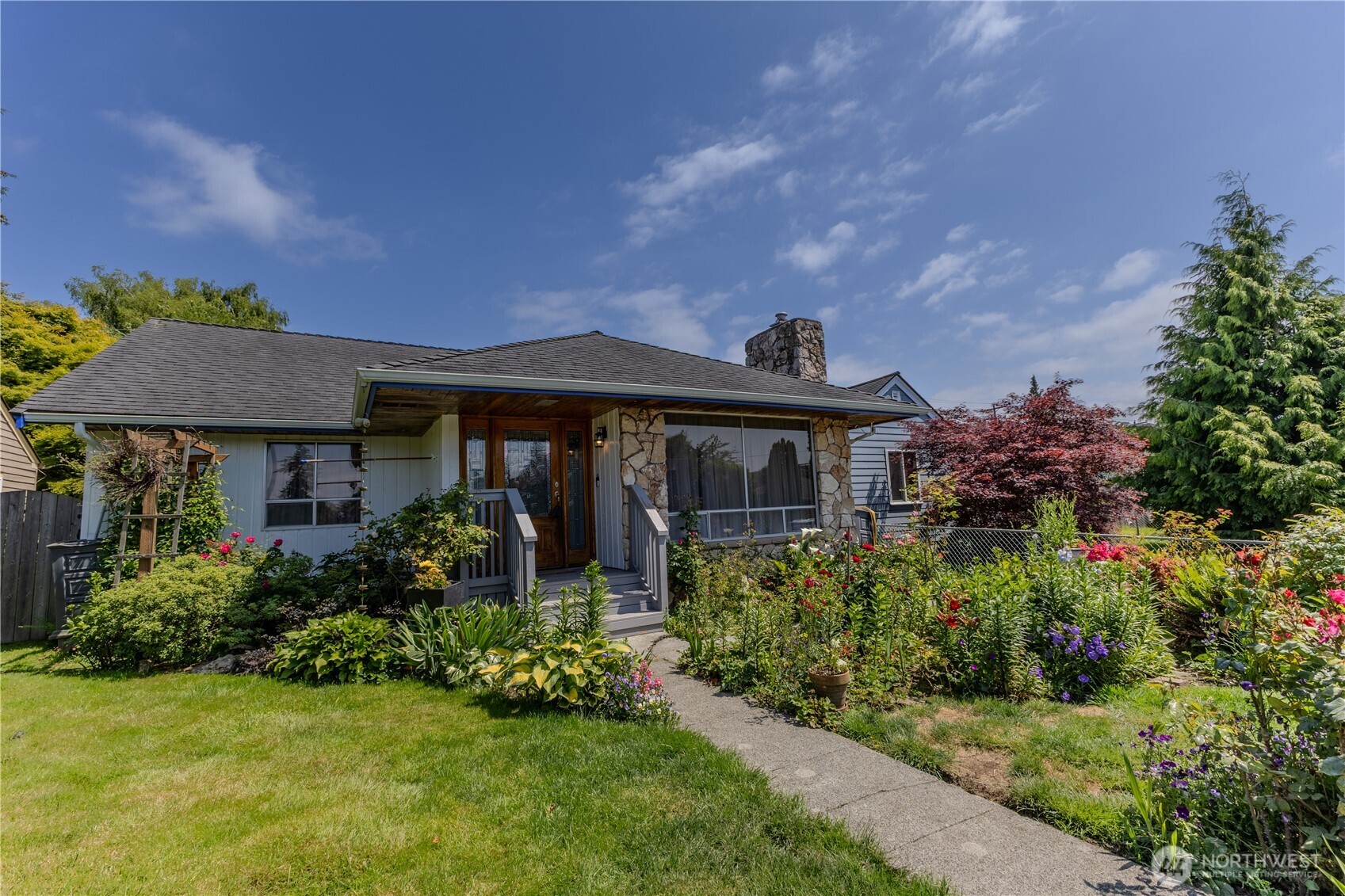 a front view of house with a yard and a garden