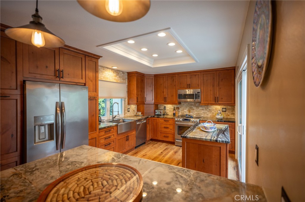 19 Windsong Irvine, CA 92614 - Photo 20 of 46 a view of a kitchen with kitchen island a large window cabinets a sink and stainless steel appliances