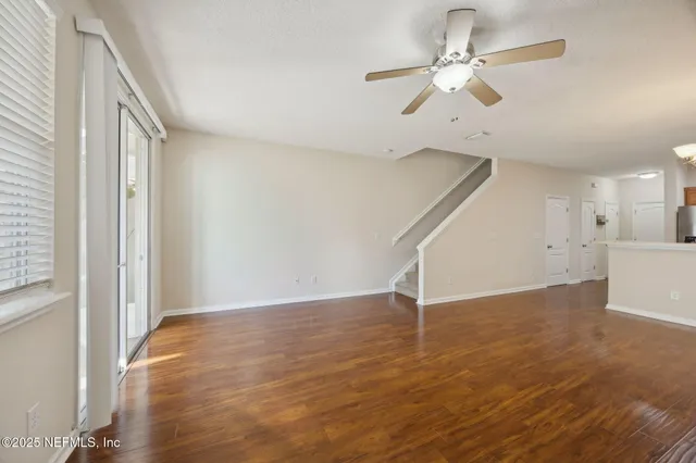 wooden floor in an empty room with a ceiling fan