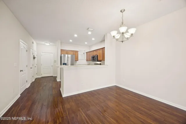 a view of a kitchen with wooden floor and a chandelier