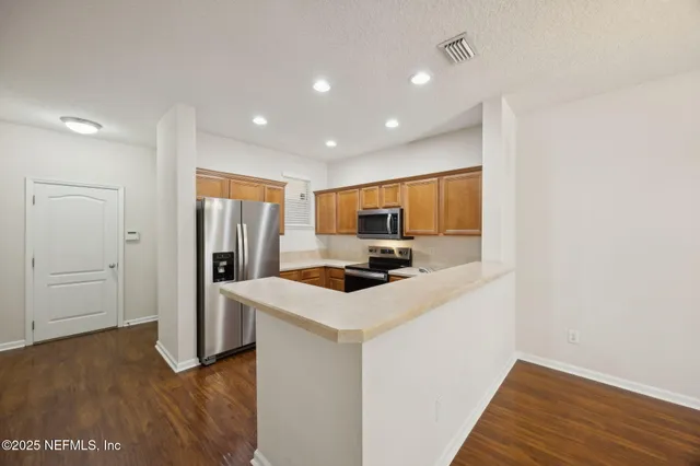 a kitchen with a refrigerator and a stove top oven