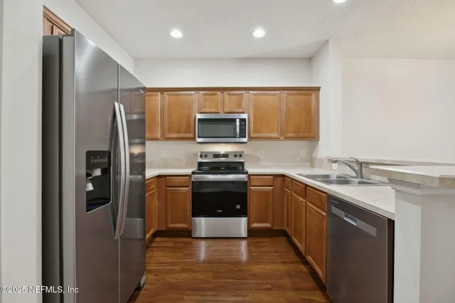 a kitchen with stainless steel appliances granite countertop a refrigerator and a stove top oven