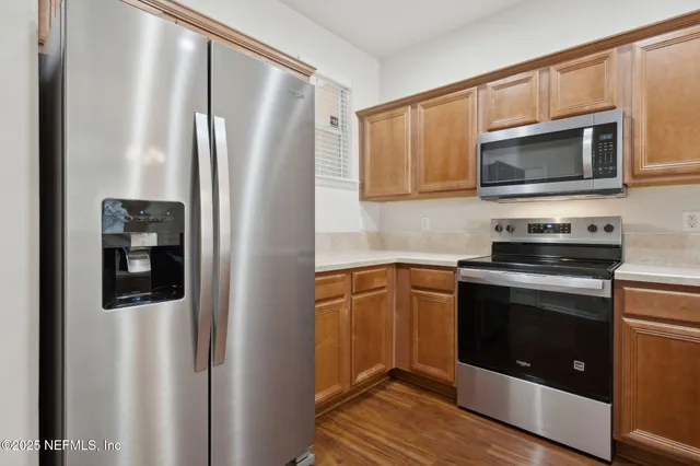 a kitchen with stainless steel appliances a refrigerator stove and microwave