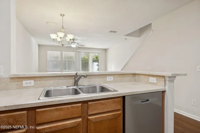 a view with granite countertop a sink and cabinets