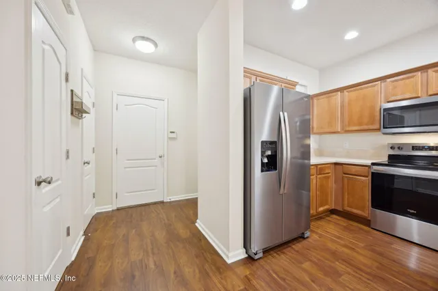 a kitchen with stainless steel appliances a refrigerator and a stove top oven