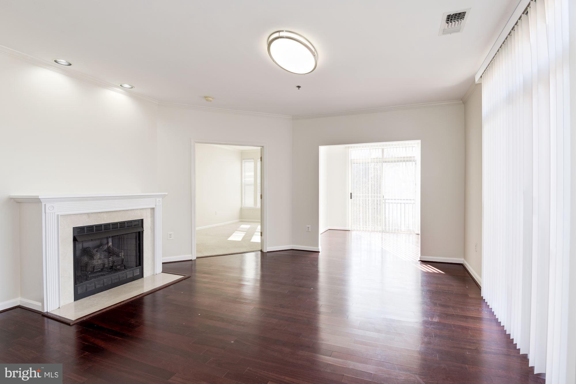 1860 Stratford Park Place, Unit 204 Reston, VA 20190 - Photo 13 of 41 a view of an empty room with wooden floor and fireplace