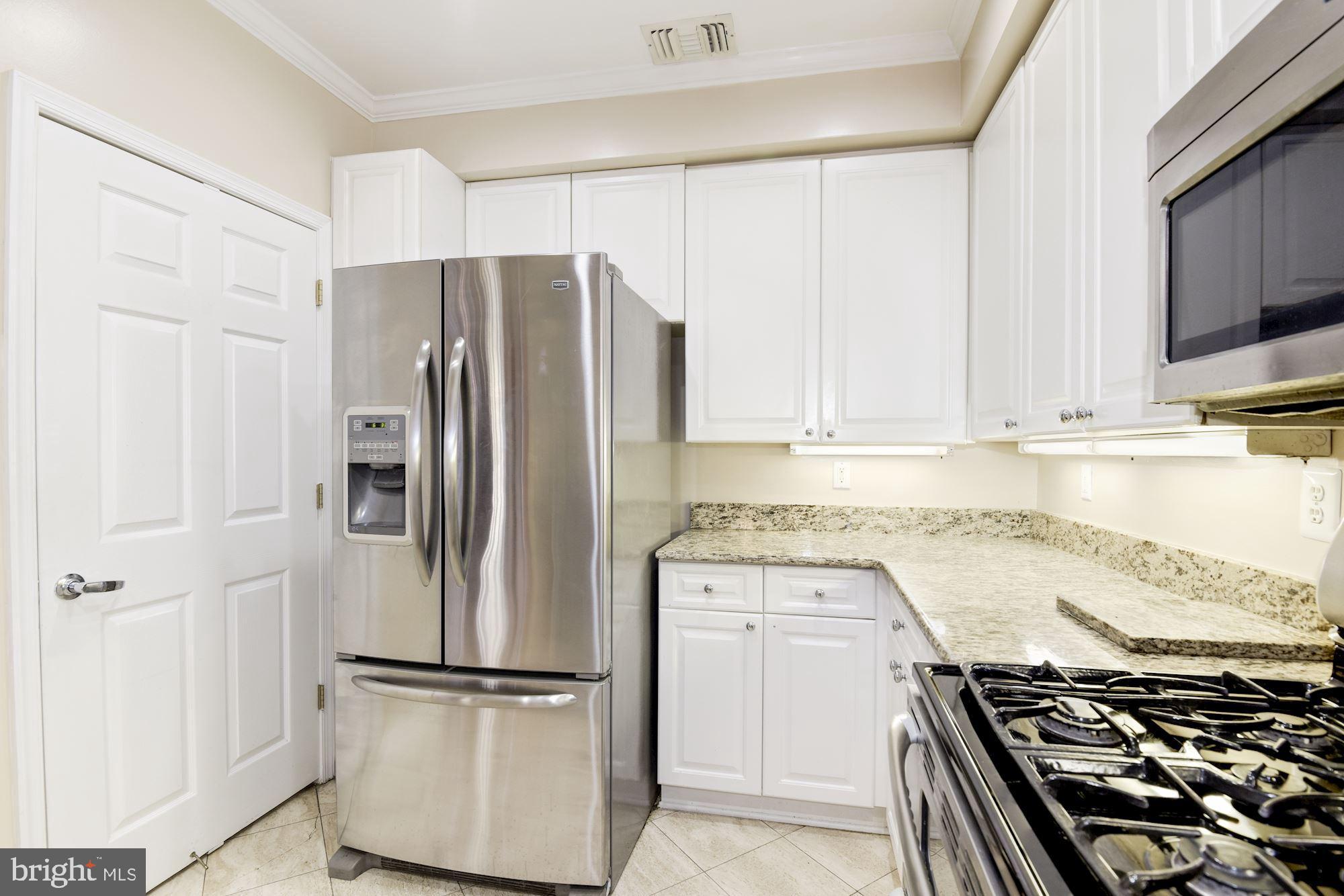 1860 Stratford Park Place, Unit 204 Reston, VA 20190 - Photo 16 of 41 a kitchen with stainless steel appliances granite countertop a refrigerator stove and sink
