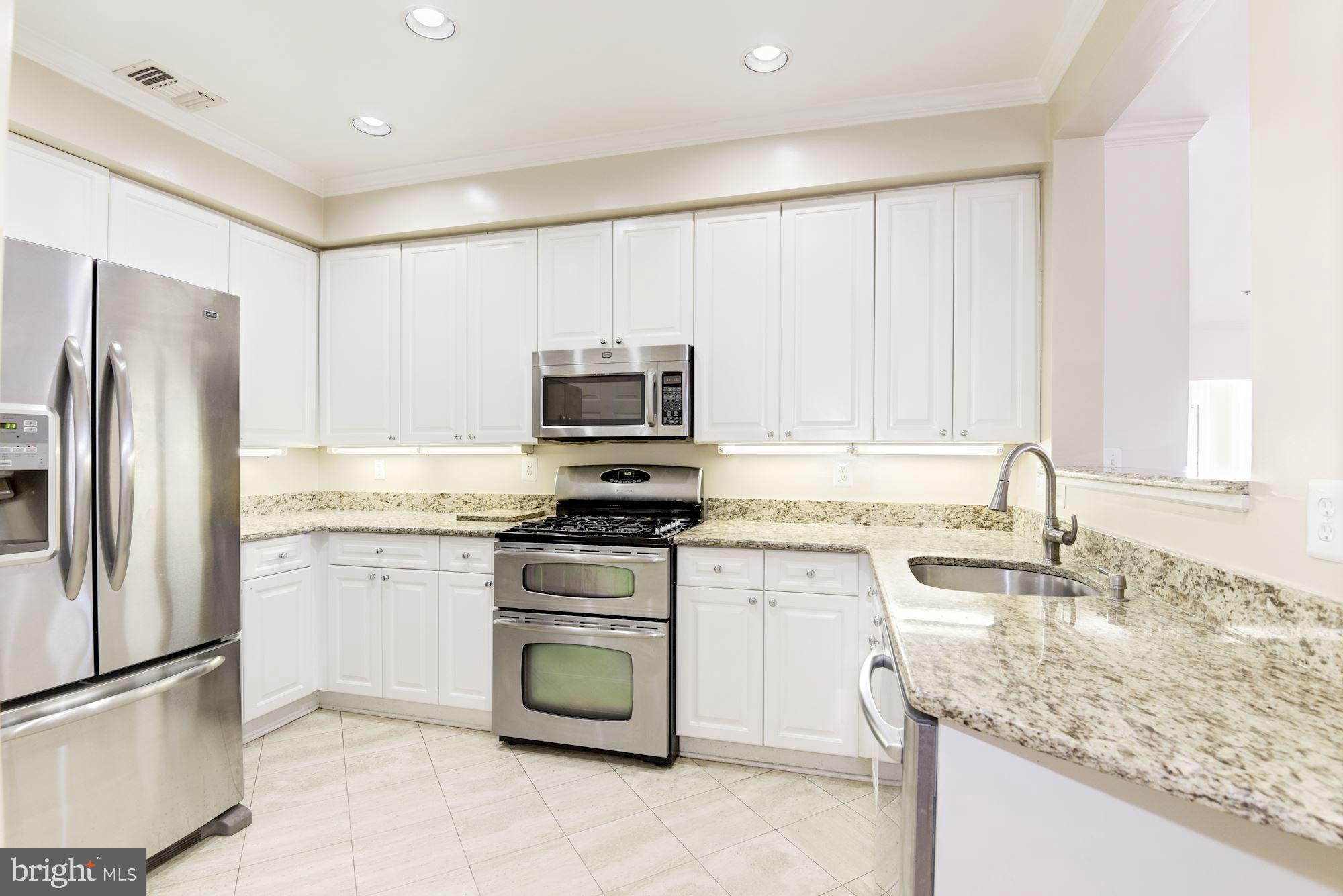 1860 Stratford Park Place, Unit 204 Reston, VA 20190 - Photo 18 of 41 a kitchen with stainless steel appliances granite countertop a sink stove and refrigerator