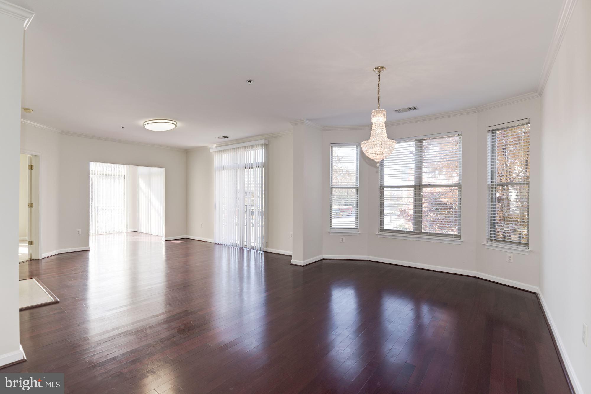 1860 Stratford Park Place, Unit 204 Reston, VA 20190 - Photo 3 of 41 a view of an empty room with wooden floor and a window