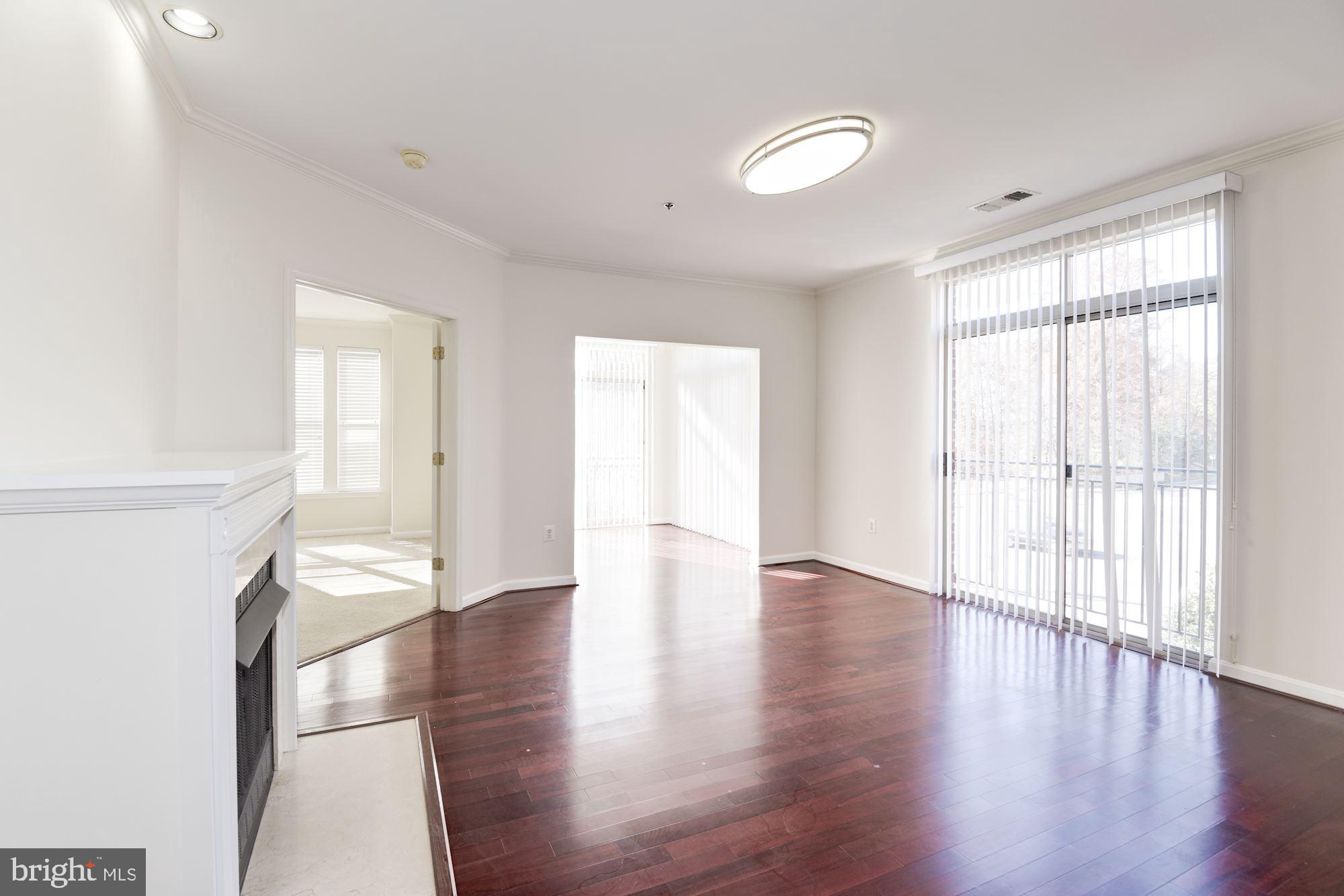 1860 Stratford Park Place, Unit 204 Reston, VA 20190 - Photo 5 of 41 a view of an empty room with wooden floor and a window