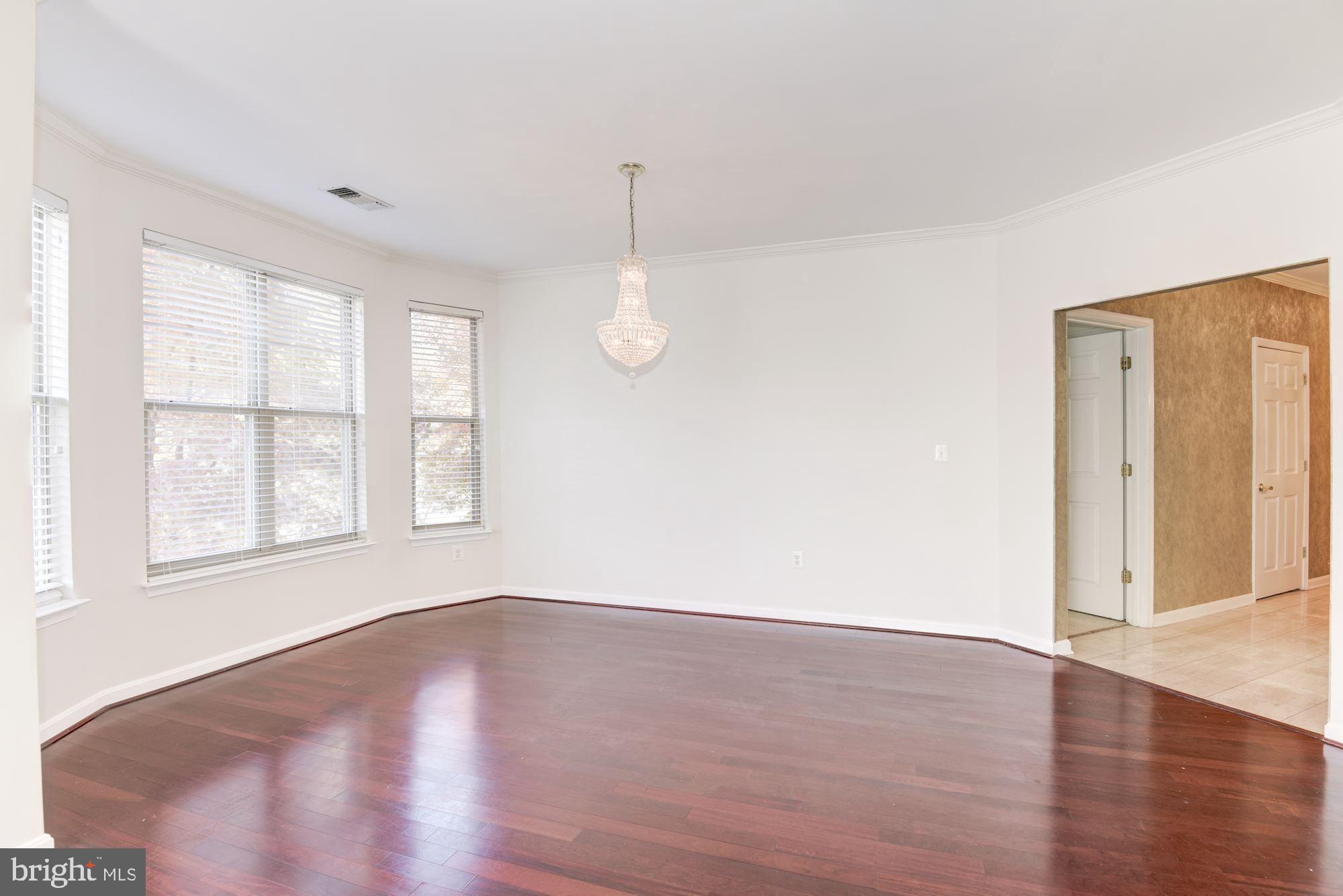 1860 Stratford Park Place, Unit 204 Reston, VA 20190 - Photo 8 of 41 an empty room with wooden floor and windows