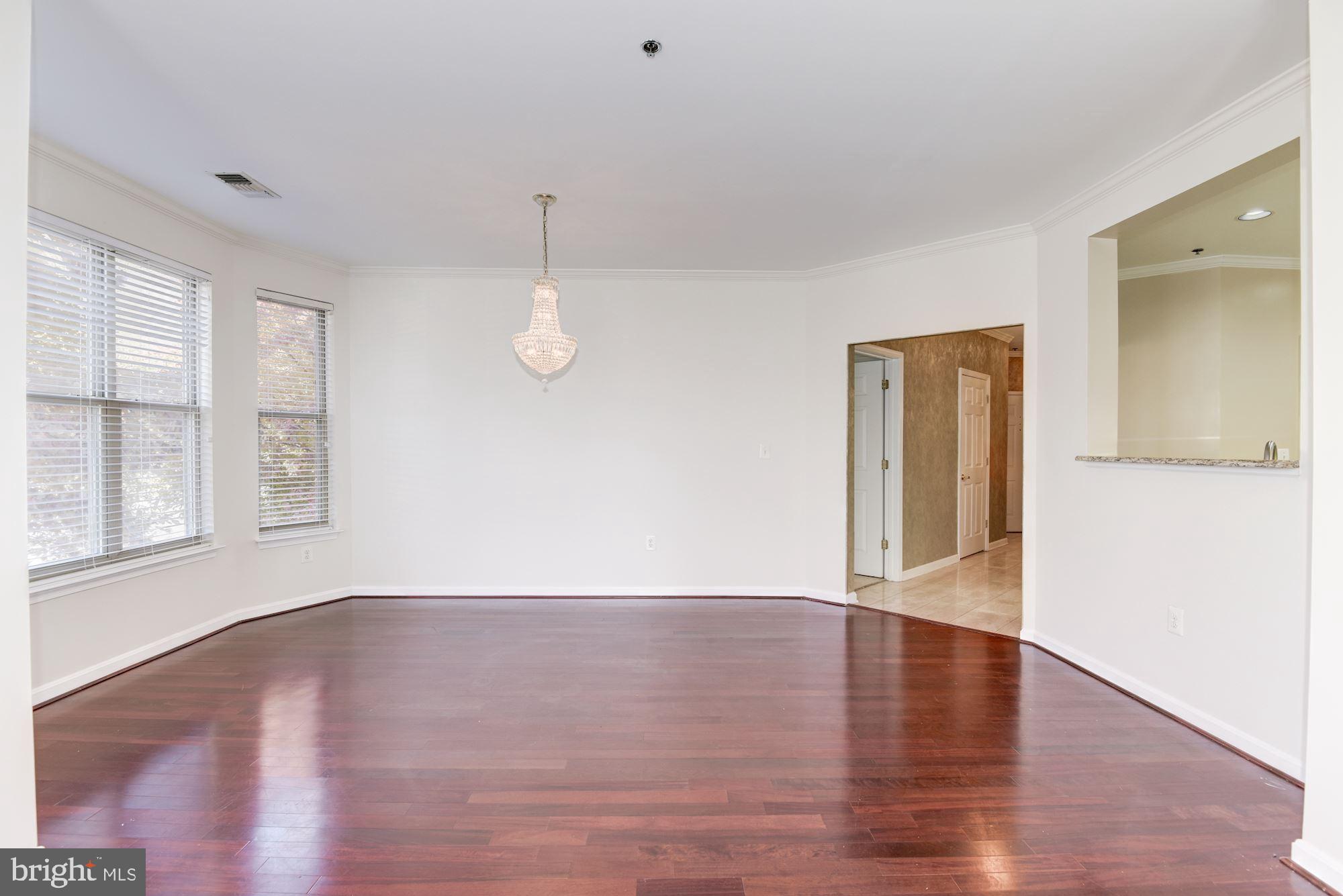 1860 Stratford Park Place, Unit 204 Reston, VA 20190 - Photo 9 of 41 a view of an empty room with wooden floor and a window
