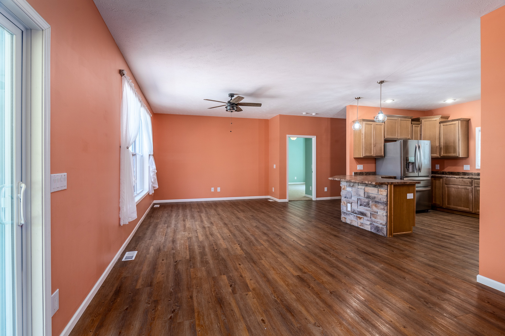 18562 East Hill Street Mount Vernon, IL 62864 - Photo 6 of 43 a view of a kitchen with a sink and an empty room with wooden floor