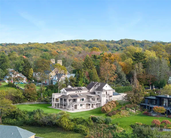 an aerial view of ocean and residential houses with outdoor space