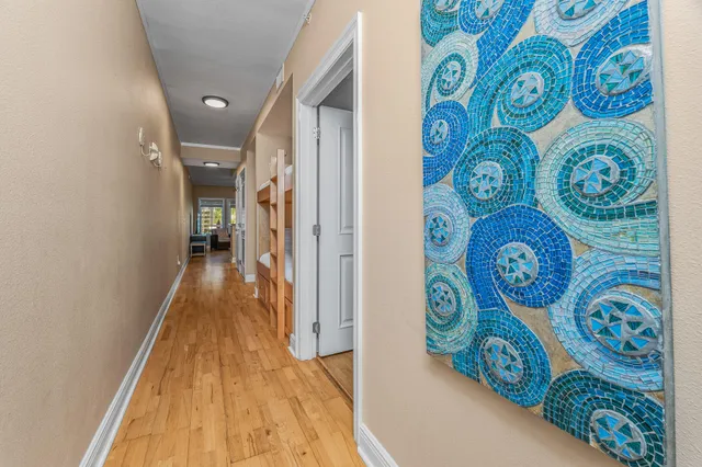 a hallway with painting on the wall and a large mirror