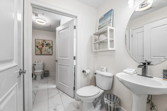 a bathroom with a sink toilet and a mirror