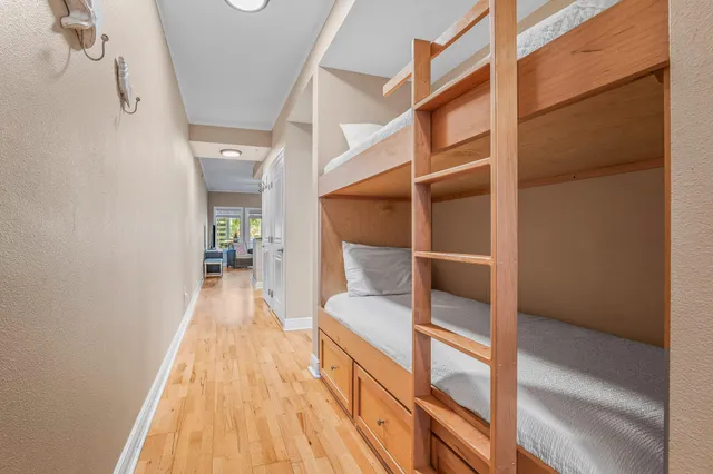 a hallway with a white cabinets and wooden floor